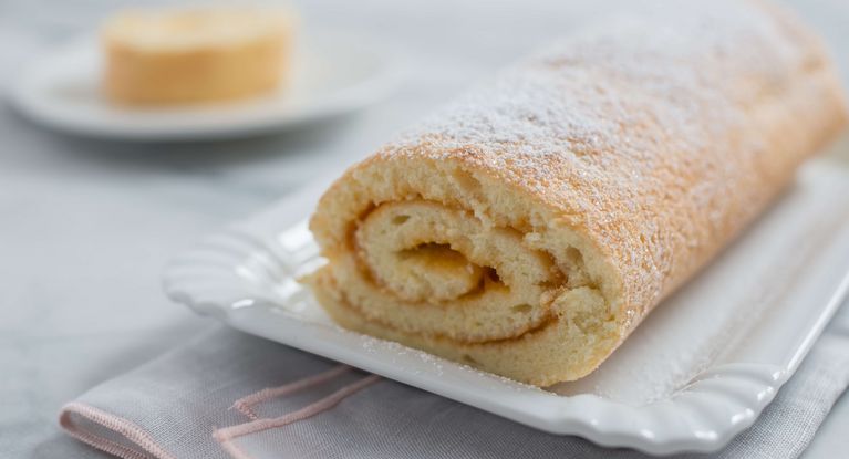 eine Sahne-Kuchen Rolle auf einem Teller