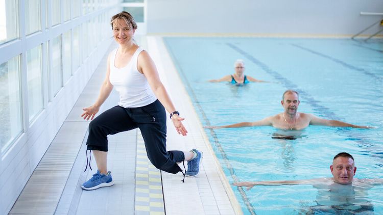 Therapeutin motivert Patienten bei der Wassergymnastik