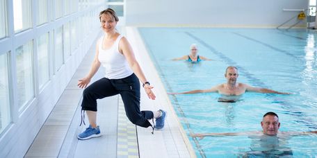 Therapeutin motivert Patienten bei der Wassergymnastik