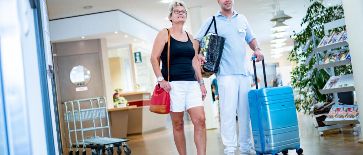 Serviekraft begleitet Patientin bei der Ankunft in der Klinik