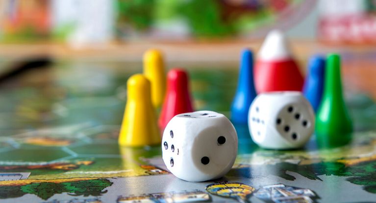 Spielfiguren und Würfel auf einem Spielbrett