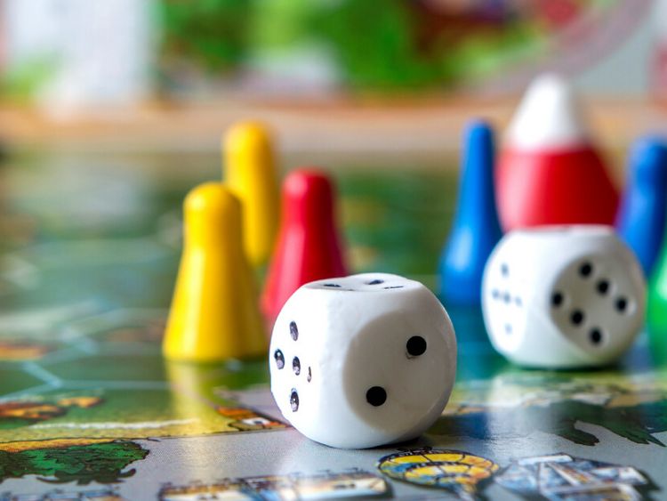 Spielfiguren und Würfel auf einem Spielbrett