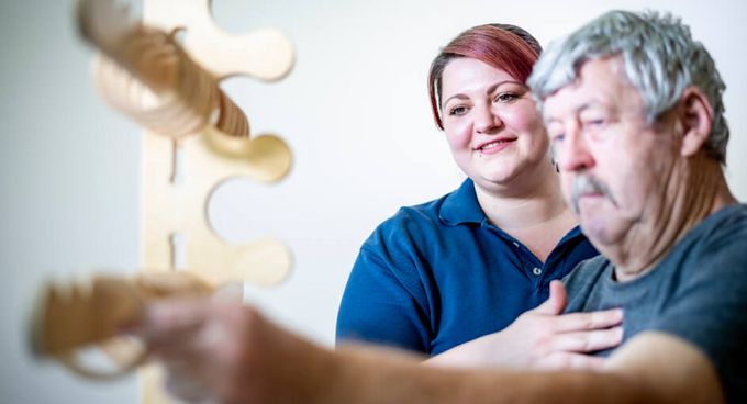 Ergotherapeutin übt mit Patient Feinmotorik