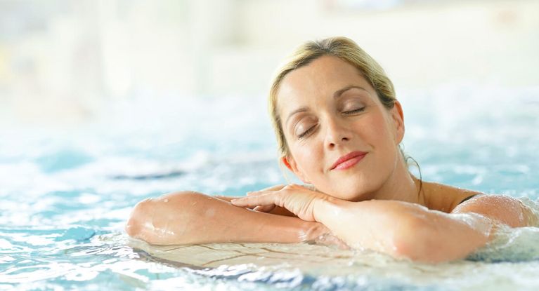 Besucherin entspannt sich im Schwimmbecken