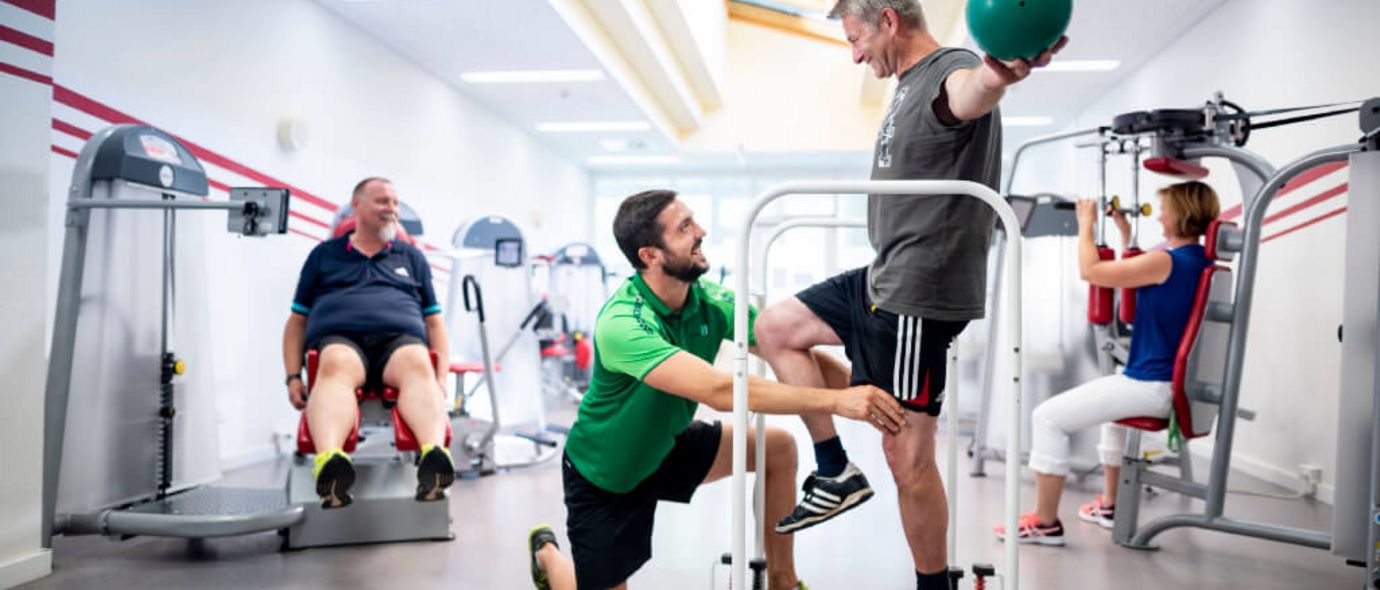 Trainer weist Patient in Geräte ein