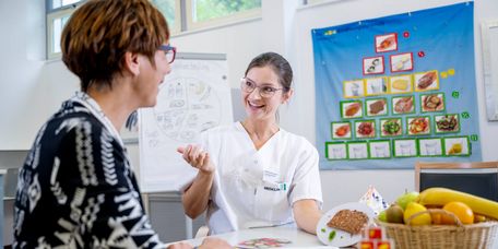 Ernäherungsberaterin erklärt Patientin die Ernährungspyramide