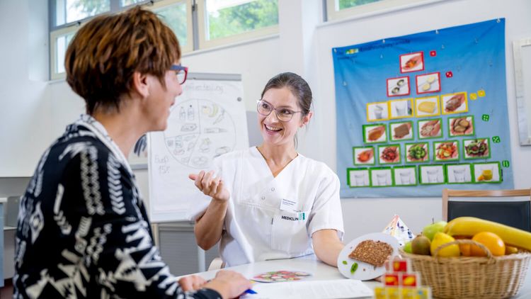 Ernäherungsberaterin erklärt Patientin die Ernährungspyramide