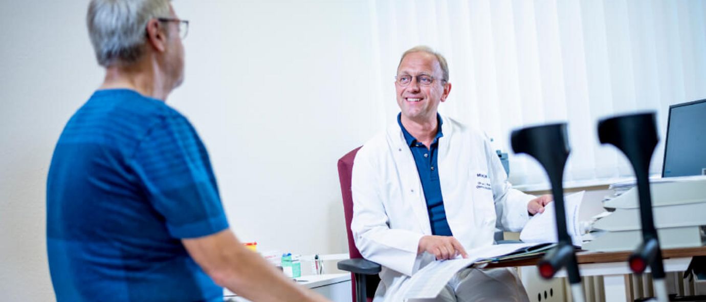 Arzt erklärt Patient seine Akte