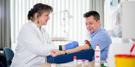Pflegekraft nimmt einem Patienten Blut ab