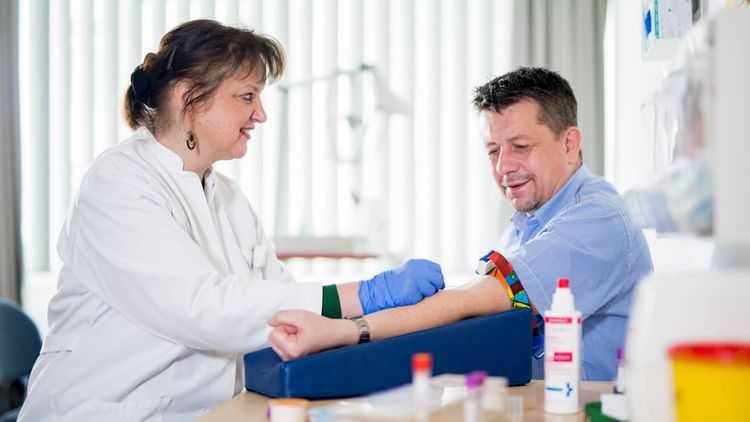 Pflegekraft nimmt einem Patienten Blut ab