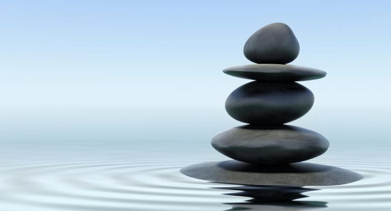 ein Turm aus Kieselsteinen unterschiedlicher Größe im Wasser+