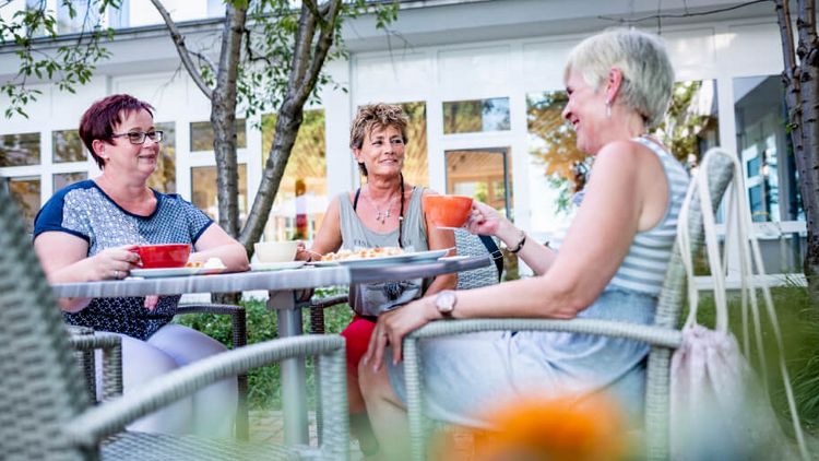 Patienten trinken draußen Kaffee