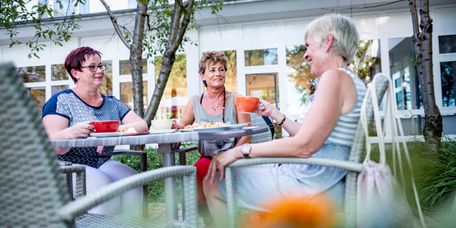 Patienten trinken draußen Kaffee