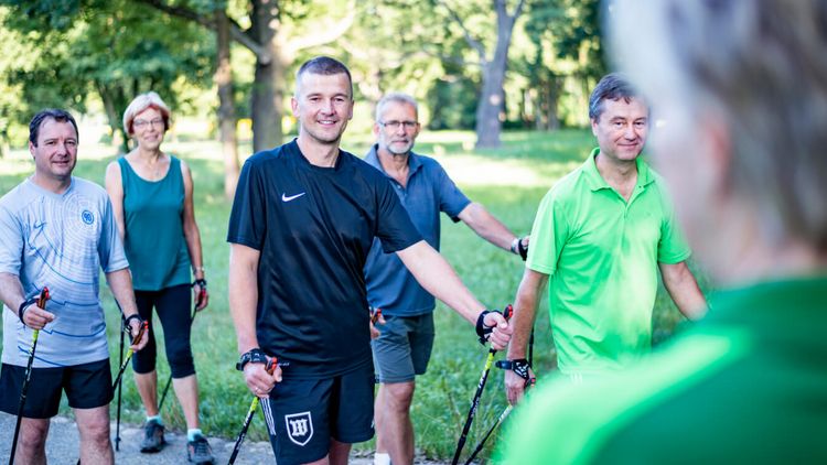 Patienten wandern in der Gruppe beim Nordic Walking