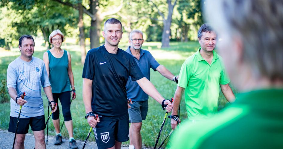 Patienten wandern in der Gruppe beim Nordic Walking