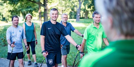 Patienten wandern in der Gruppe beim Nordic Walking