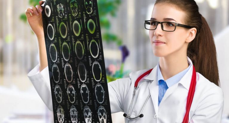 Ärztin analysiert MRT-Aufnahmen eines menschlichen Kopfes